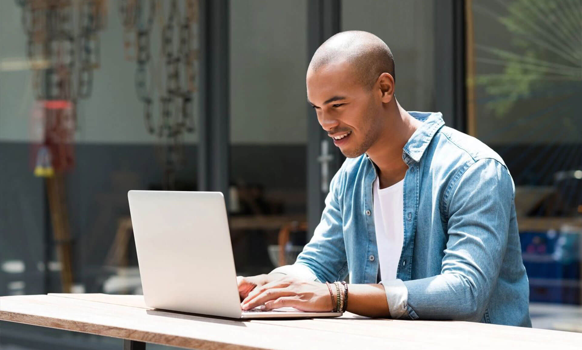 A man sitting at a table with his laptop.