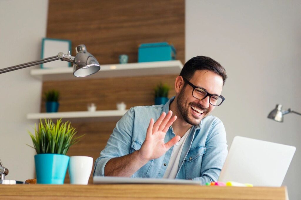 A man sitting at a table with a laptop.