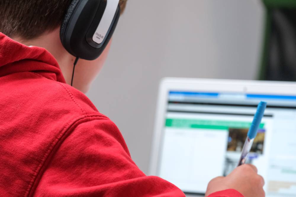 A person wearing headphones using a laptop computer.